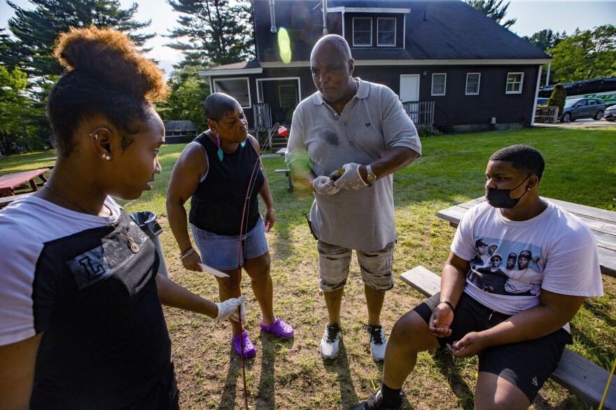 Director of Maintenance for Camp Atwater Buck Gee demonstrates to campers how to remove a hook from a sun fish. Gee attended the camp as a child and has been working here for 40 years.