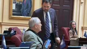Senate Majority Leader Scott Surovell, center, talks to Senator Dave Marsden about the casino bill as Senator Jennifer Boysko listens from a distance.