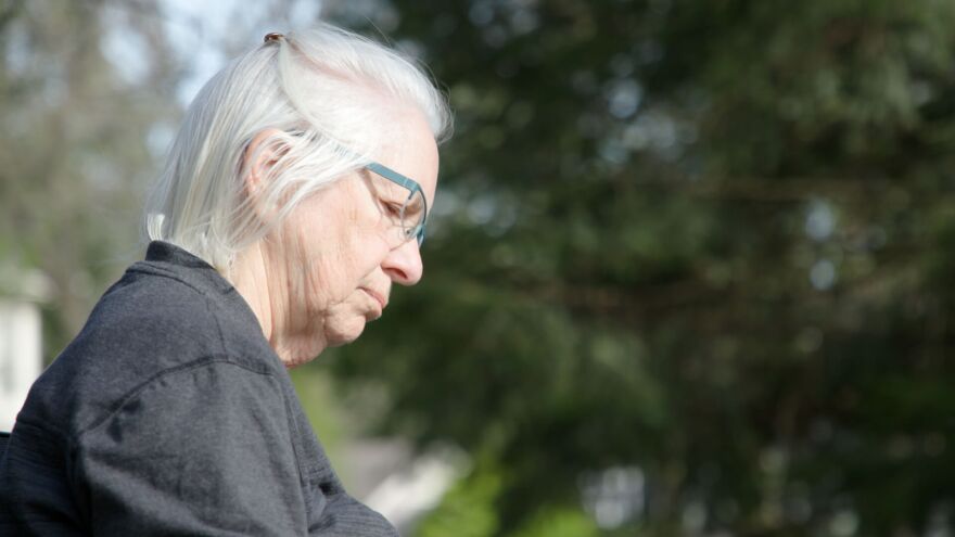 Susan Bailey sits on a bench along Blackstone Boulevard in Providence during her intergenerational class at School One
