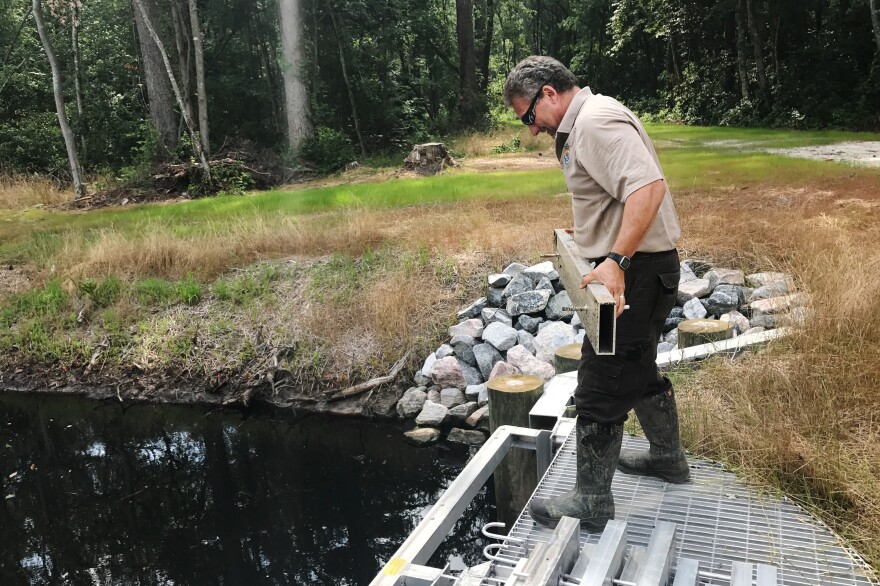Chris Lowie, refuge manager at the Great Dismal Swamp National Wildlife Refuge, demonstrates how the newly installed water control structures work.