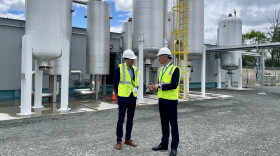 Waga Energy executives Guénaël Prince (left) and Tanguy Largeau stand in front of the WAGABOX facility at the Steuben County Landfill in Bath, NY. The facility converts landfill emissions into energy.