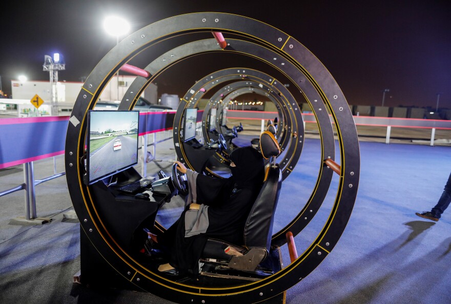 A Saudi woman sits in a driving simulator during an awareness campaign in Jeddah on June 21.