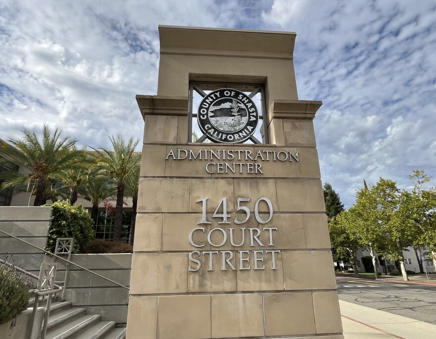 A large stone marker outside reads 'administration center' with the address. Behind are palm trees and blue sky. 