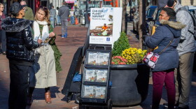  A woman shares Jehovah's Witnesses' literature with a passerby on a street corner