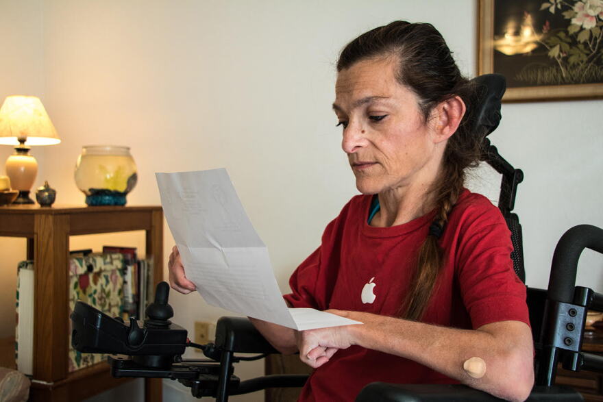 Lori Taylor reads the second letter she received from the state Department of Human Services informing her that her Medicaid waiver program will be funded temporarily. 
