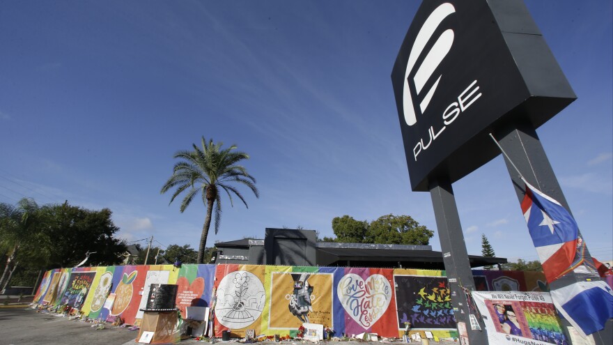 In this Nov. 30, 2016, photo, artwork and signatures cover a fence around Pulse nightclub, which was the scene of a mass shooting in Orlando.