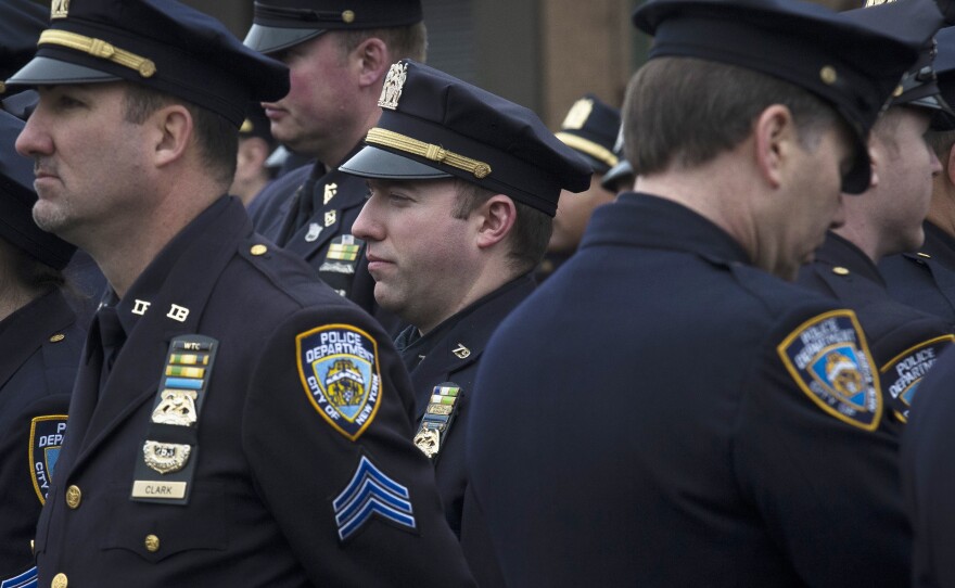 Police officers turn their backs as Mayor Bill de Blasio speaks during the funeral of New York Police Department Officer Wenjian Liu at Aievoli Funeral Home Sunday.