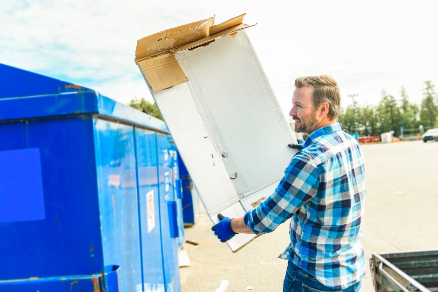 A worker recycling cardboard at a recycle center