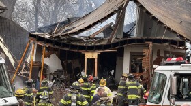 Rochester firefighters work to extinguish remaining hot spots after an apparent house explosion on Tuesday, April 14, 2026, destroyed a 2 1/2-story rental home at 1128 Lake Ave.
