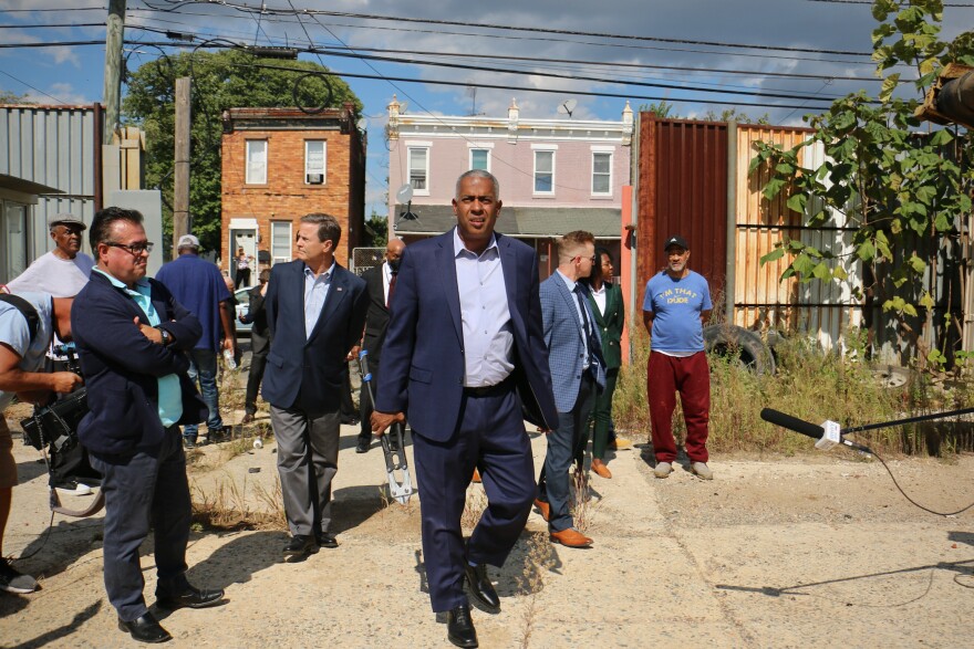 Camden Mayor Vic Carstarphen (center) walks into a private dump site at 7th and Chestnut streets after cutting the chains on the gate. The city has reached an agreement to begin cleanup on the privately owned property.