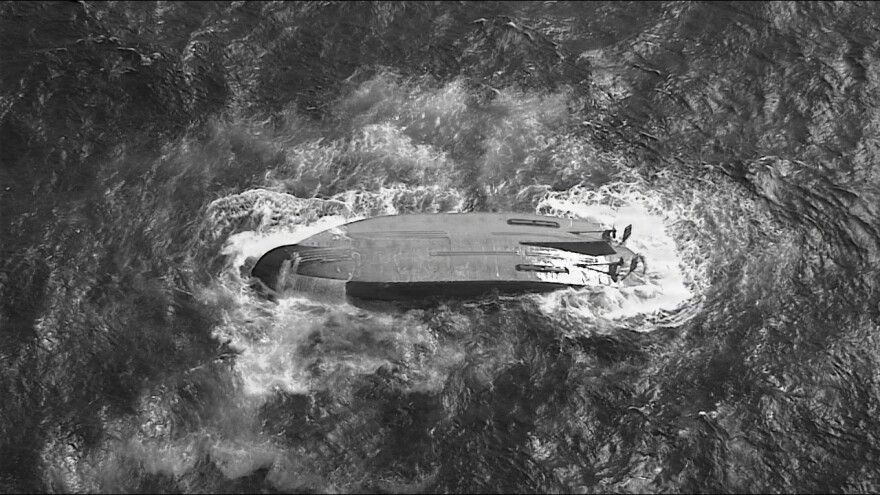 A U.S. Coast Guard HC-130 Hercules airplane crew assigned to Coast Guard Air Station Barbers Point flies over an overturned vessel offshore Saipan, April 18, 2026.