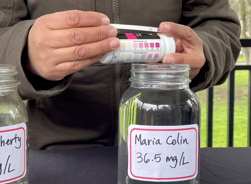 Oregon Rural Action's Ana Maria Rodriguez conducts a rapid test on a jar of water brought from Boardman, OR., which tested above the federal standard of 10 miligrams per liter.