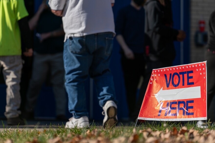 A "Vote Here" sign guides voters at Valley High School.