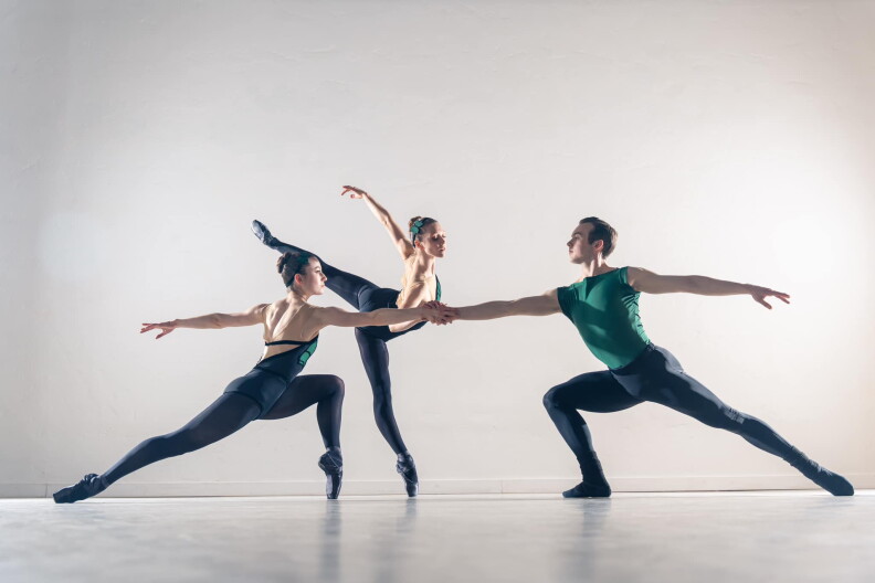 Three people dance on a stage.