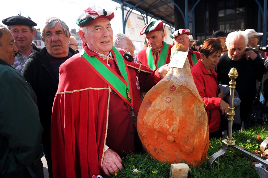 A member of the Bayonne ham authority, <em>La Confrerie du Jambon de Bayonne</em>, with a ham on the first day of the 2014 Bayonne ham fair in southern France.