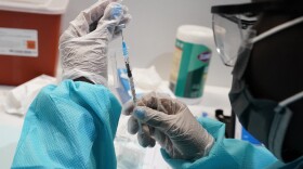A health care worker fills a syringe with the Pfizer-BioNTech COVID-19 vaccine at the American Museum of Natural History in New York City this year.