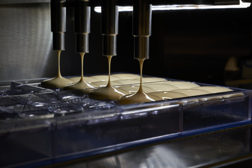 Cannabis-infused chocolate drops into molds from a one shot chocolate dosing machine at the Proper Brands kitchen. The company is one of only a few making infused chocolate in the state.