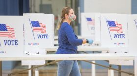 An election worker moves between voting booths at a polling location in Hermon, Maine. 