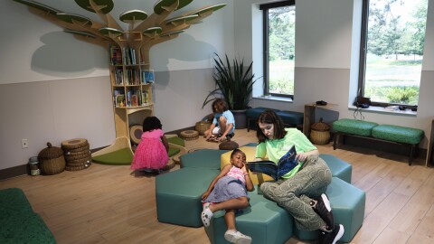 Quinn Gaul, a staff member at the newly opened Maplewood Nature Center, reads a book to Amber, 6, during a City of Rochester recreation camp in Rochester. The center features interactive environmental education, a story corner, hands-on exhibits and programs designed to connect children with nature.
