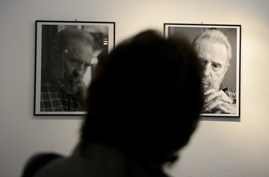 A visitor watches pictures taken by Cuban photographer and cinematographist Alex Castro, son of former Cuban president Fidel Castro.