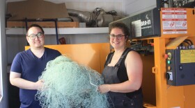 Basil Tilden and Nicole Baker in front of their compactor, which squishes fishing nets into 350 lb. bales.