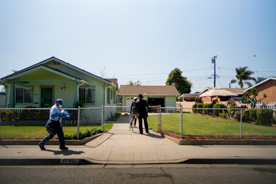 Robert Lee Johnson speaks with a resident in his childhood neighborhood. He says Compton felt like a "step into another world" compared with the public housing complex his family was living in prior to their move. Though their new home was shared with his brothers, it was spacious.