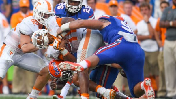 A swarm of Florida defenders tackle Tennessee quarterback Joshua Dobbs (11).