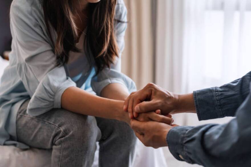 Young man comforting and supporting a sad woman who is in serious trouble at home, Consolation and encouragement concept.