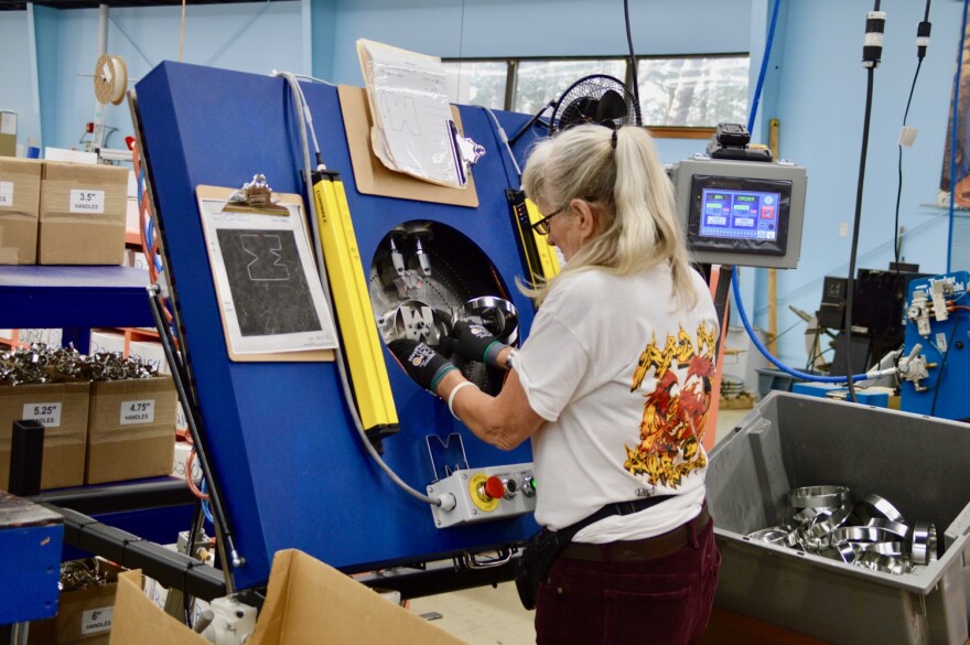 An Ann Clark employee makes a cookie cutter shaped like the letter "M." 