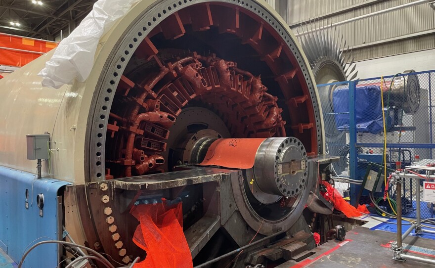 A massive metal cylinder sits open with turbine parts inside exposed during inspections at the Palisades nuclear plant.