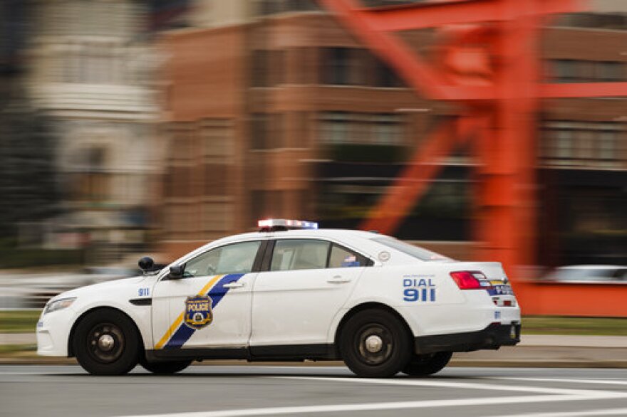 A police car drives with its lights flashing in Philadelphia, Tuesday, Jan. 8, 2019. (AP Photo/Matt Rourke)
