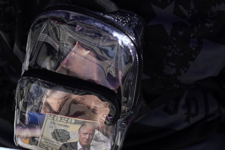 A supporter of President Donald Trump has a clear plastic backpack during a campaign rally at MBS International Airport, Thursday, Sept. 10, 2020, in Freeland, Mich.