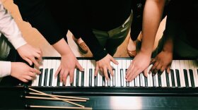 Students in a music therapy session playing together on the keyboard