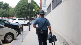  A Kansas Highway Patrol trooper walks to a car in a parking lot.