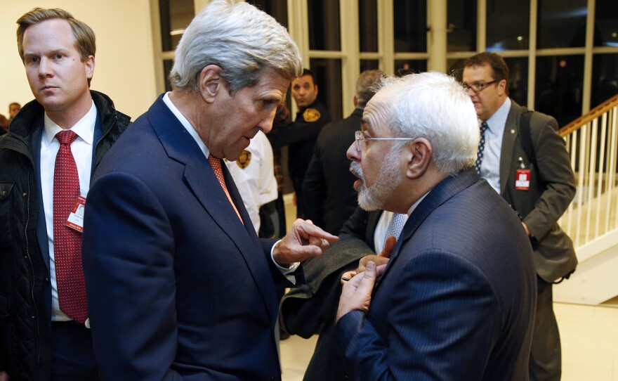 U.S. Secretary of State John Kerry (left) speaks with Iranian Foreign Minister Mohammad Javad Zarif after the IAEA verified that Iran has met all conditions under the nuclear deal.