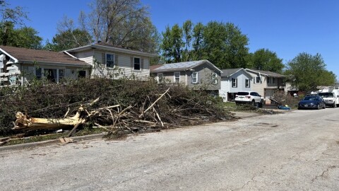 A view of debris stacked up on a residential street after a storm