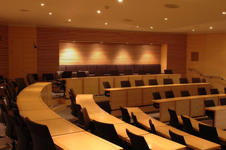 Several rows of a college classroom in dark brown and yellow tones.