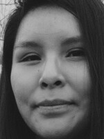 Close-up of a woman smiling at the camera in front of a dry thicket