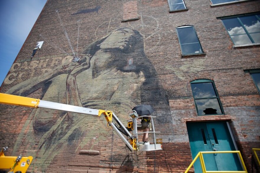 South African artist Faith47 paints "Rhapsody" on the Lofts at Michaels-Stern on Pleasant Street in 2012.