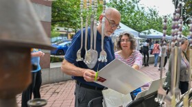 Mark and Tiffany Ciocca of Old Forge look at his illustration and printmaking pieces at the Fine Arts Fiesta.