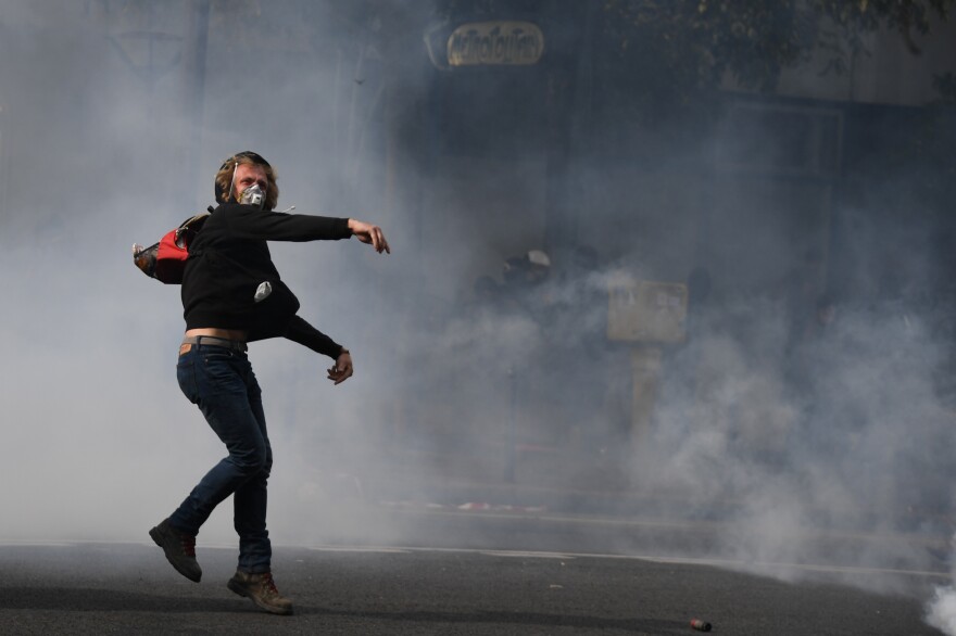 A demonstrator throws a projectile during a protest Tuesday called by several French unions in Paris.