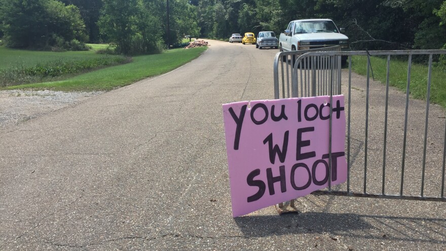 A handmade sign offers a stern warning at the entrance to an abandoned neighborhood where people have lost so much.