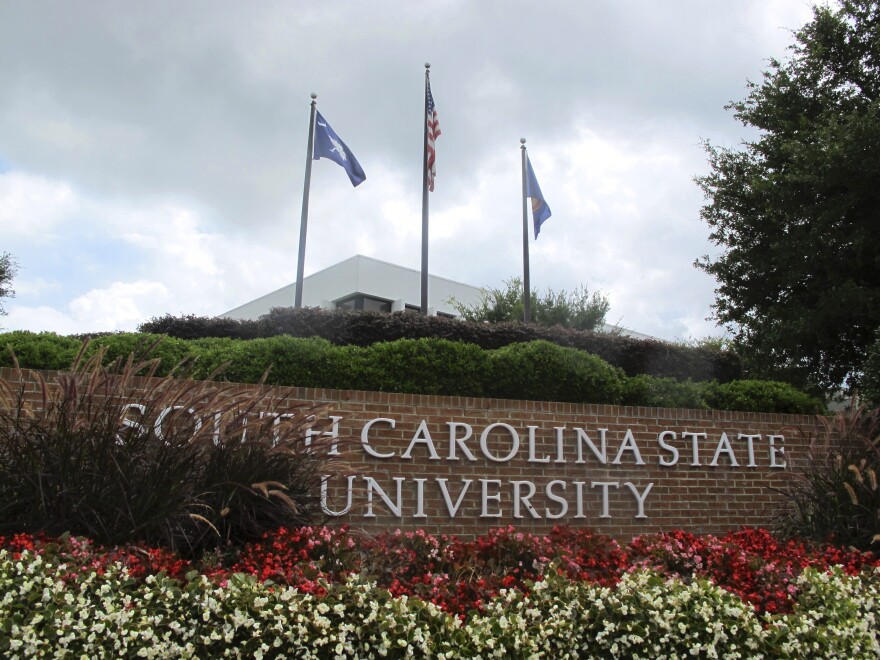 FILE - In this July 22, 2014, file photo, flags fly at the entrance to South Carolina State University in Orangeburg, S.C. A student faces charges after a shooting at South Carolina State University on Tuesday, Feb. 6, 2024 that sent the campus into lockdown for nearly one hour but did not leave any reported injuries. (AP Photo/Bruce Smith, File)