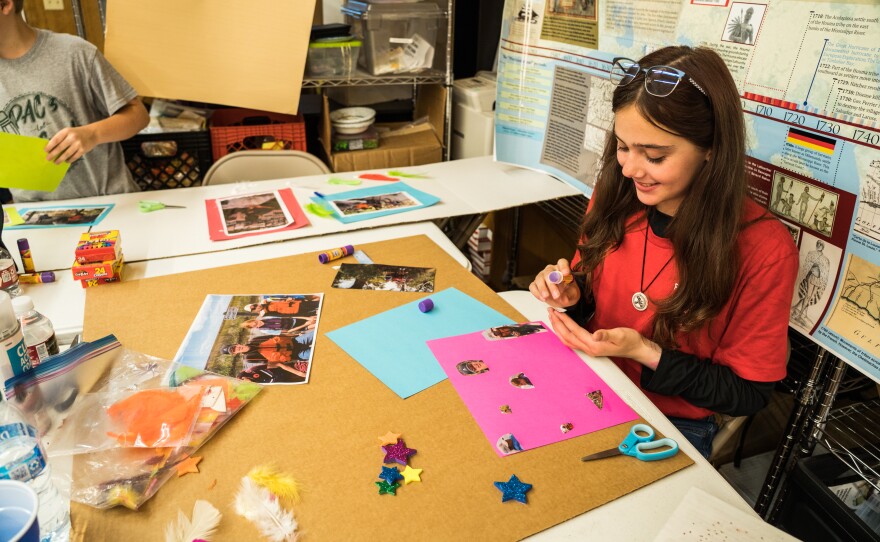 Lilly Ferguson decorates her post board with what she's learned during her week at culture camp.