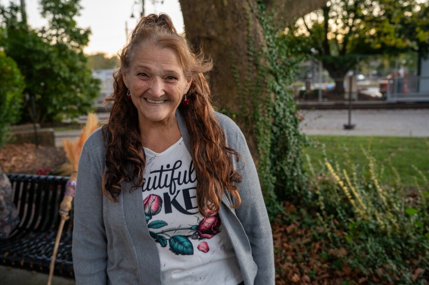Women stands and smiles in park.