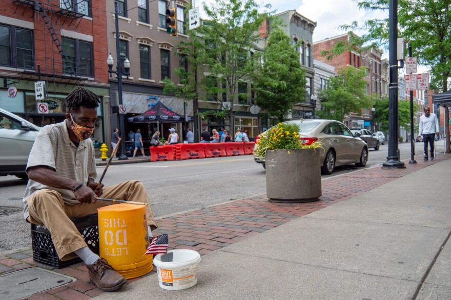 A street performer plays for donations as restaurants and bars begin to reopen in the wake of the COVID-19 pandemic, Saturday, May 16, 2020, in Cincinnati.