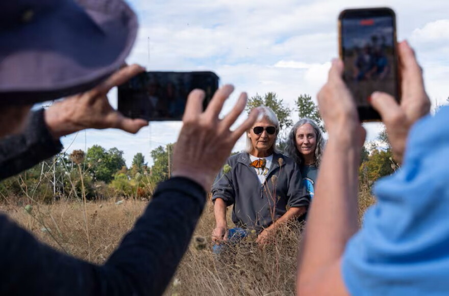 David James, left, and Ida Galash pose with a monarch butterfly fitted with an electronic tag in Oaks Bottom Wildlife Refuge in Portland, Ore., on Sept. 5, 2026. James, an entomology professor at Washington State University, has been studying the migration patterns of monarchs in the Pacific Northwest for over a decade.