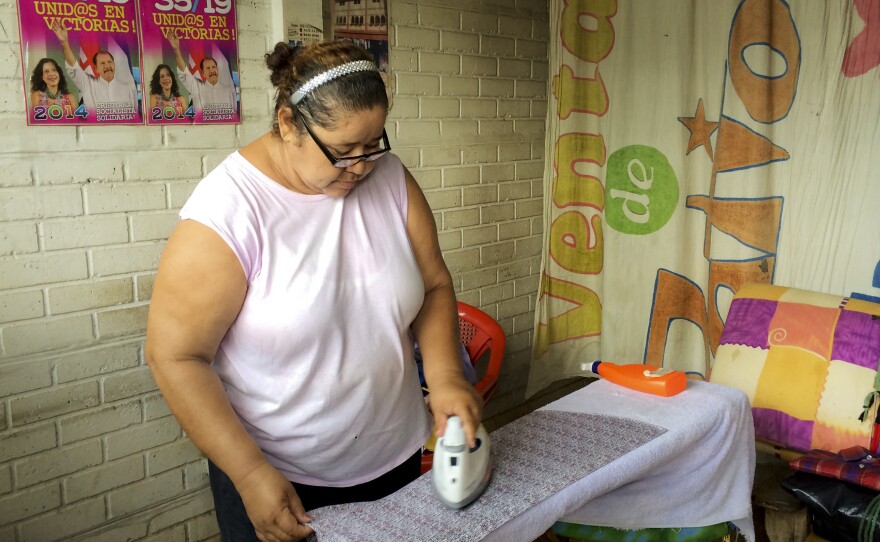 Marina Loza irons in her government-built brick house, which she shares with another family. She says the first couple will stay in power as long as they keep doing right by the country's poor.