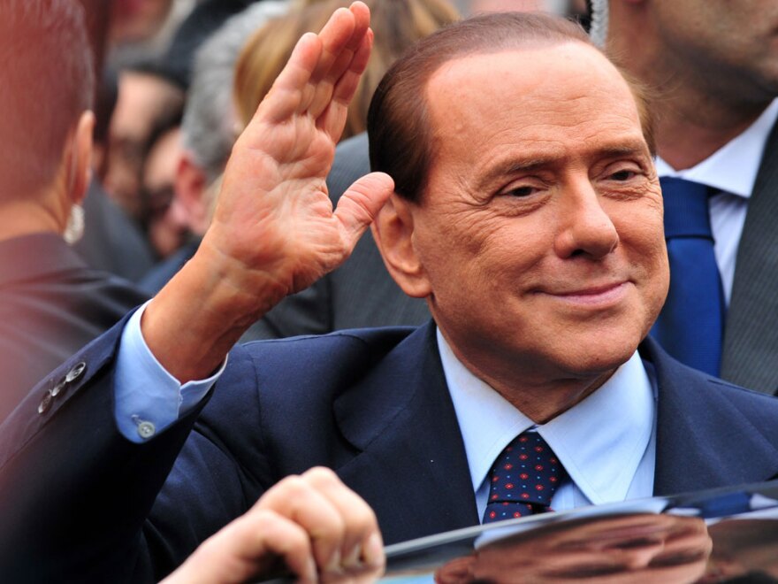 Italian Prime Minister Silvio Berlusconi acknowledges his supporters at legal hearing over allegations of fiscal fraud and breach of trust in his business interests on March 28 at Milan's justice court.