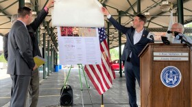 Onondaga County Legislature Chairman Dave Knapp (behind County Executive Ryan McMahon) and Syracuse Mayor Ben Walsh unveil FoodPlan CNY as SUNY ESF Professor and principal author Matthew Potteiger looks on behind the podium.